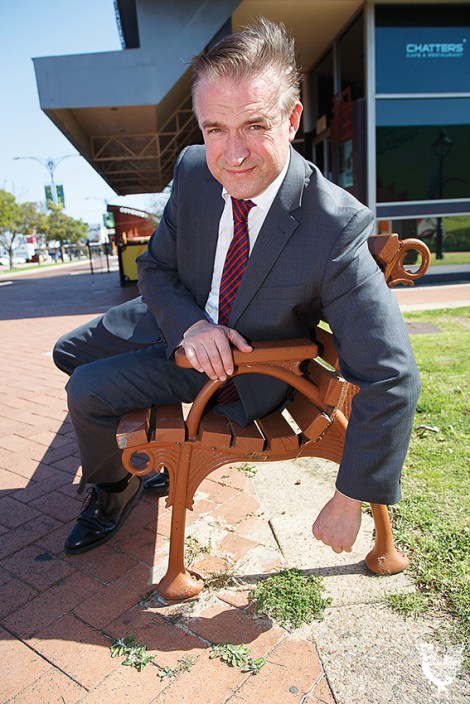 • Cr Chris Cornish at the weedy corner of Bishop and Progress Streets. Photo by Matthew Dwyer