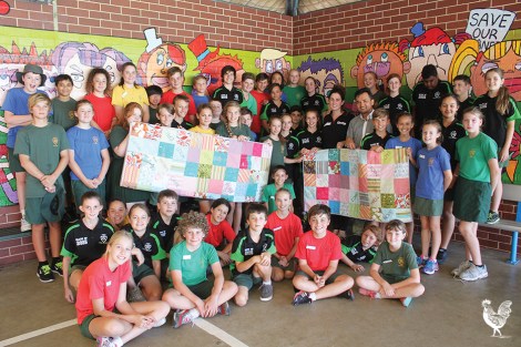 • The year six kids from Inglewood primary donate two quilts they made to Red Cross members Ashraff Mohammad and Claire Collery. Photo by David Bell