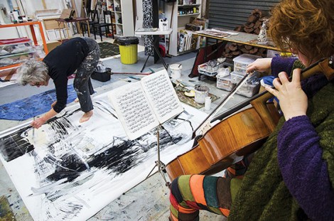 • Rachel Scott fiddles while Judith Wright paints. Photo supplied
